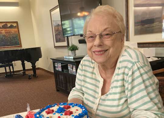 Resident celebrating with patriotic decorated cake at Hilltop Commons Senior Living Apartments, Grass Valley, CA