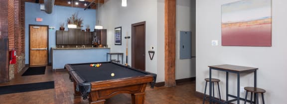 a game room with a pool table and a kitchen