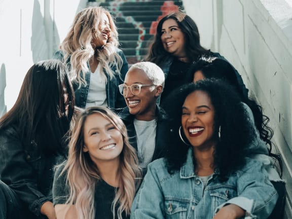 a group of women sitting on stairs laughing in Medical Center area
