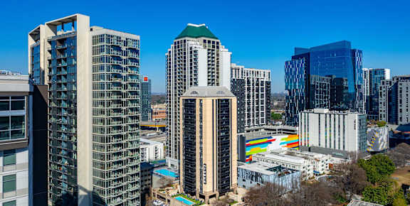 A cityscape with various buildings and a clear blue sky.