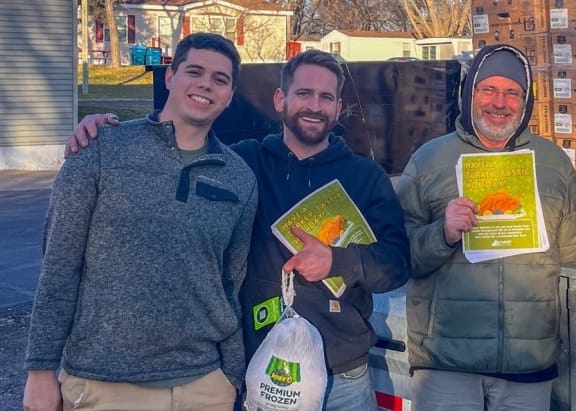 a group of men standing in front of a truck holding signs