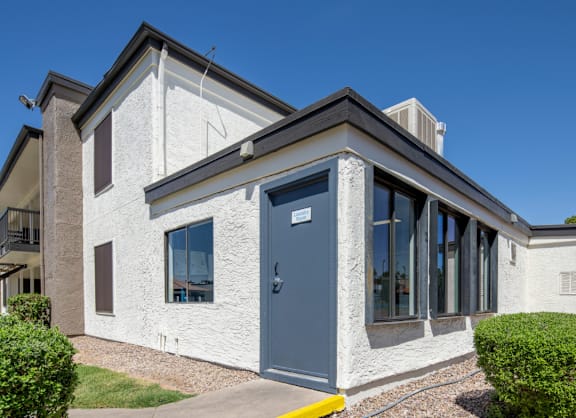 A white house with a grey door and windows.