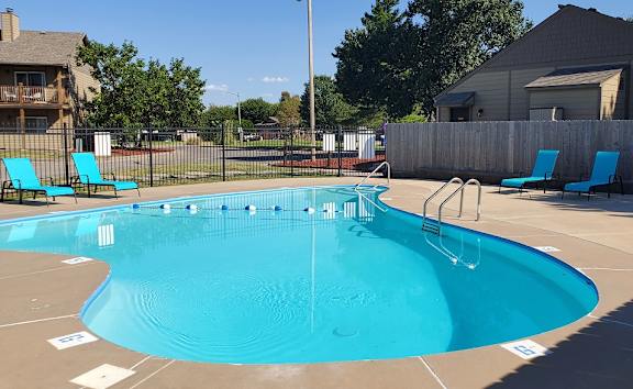 A swimming pool surrounded by lounge chairs, offers a relaxing environment at Willow Creek Apartments.
