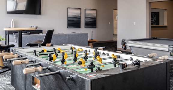 A foosball table is in the middle of a room with a black and white floor.