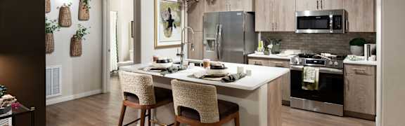 A kitchen with a table and chairs in front of a refrigerator.
