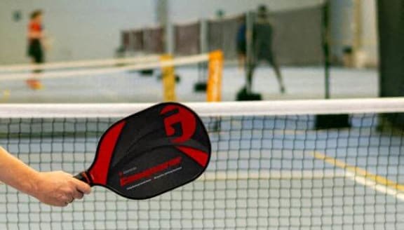 a person holding a tennis racket on a court