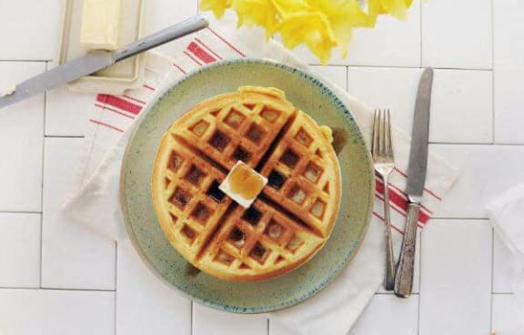 a plate of waffles with a pat of butter on top