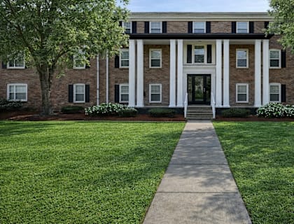 A building with a white front door and steps leading up to it.
