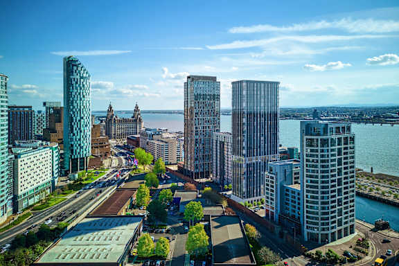 A cityscape with tall buildings and a body of water in the background.