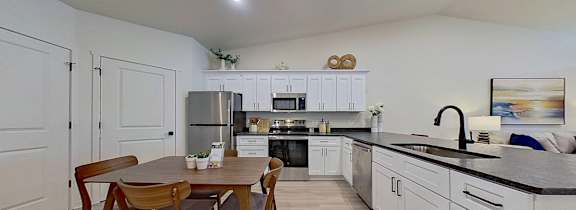 A kitchen with a table and chairs in the middle of the room.