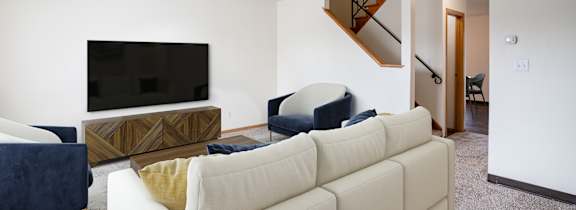 A living room with a white couch and a television. West Fargo, ND Sheyenne Terrace Townhomes