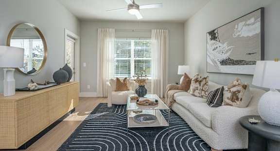 A living room with a couch, coffee table, and a painting on the wall.