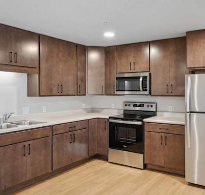 a kitchen with wooden cabinets and white countertops