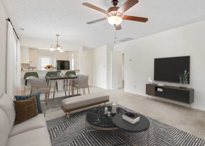 a living room with a ceiling fan and a television