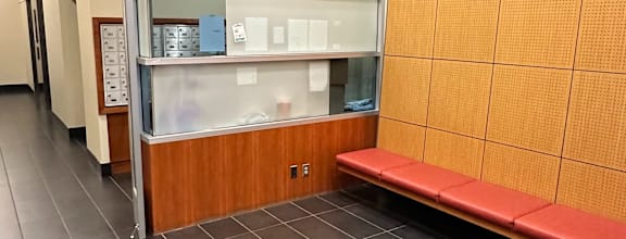 A long hallway with a bench and a wall of cabinets.