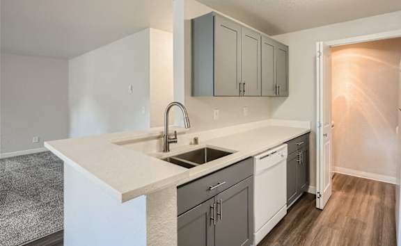 A kitchen with a white counter top and a white fridge.