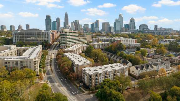 A cityscape with a clear blue sky and a few clouds.
