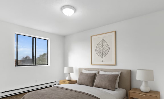 A bedroom with a large bed and a window.