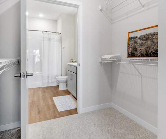 A white room with a doorway leading to a bathroom.