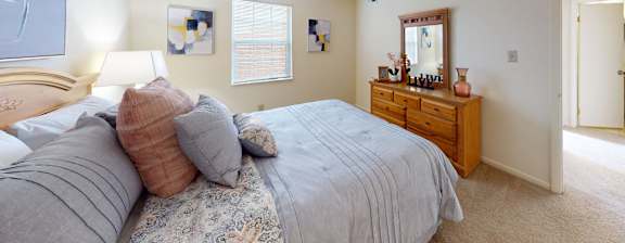 A bedroom with a bed, nightstand, and a mirror.