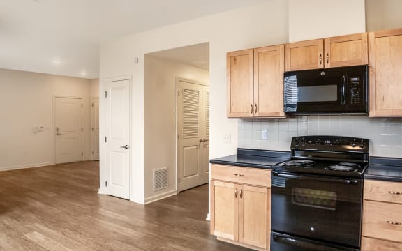 a kitchen with a stove and a microwave and wooden cabinets