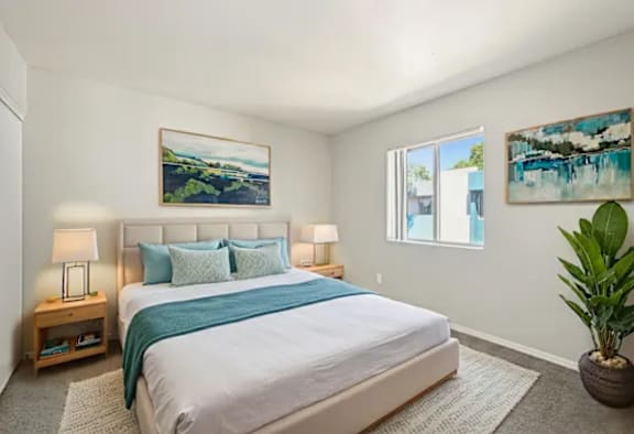 A bedroom with a large bed and a painting on the wall.