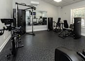 Thumbnail 25 of 32 - A gym with a treadmill, weights, and exercise machines.