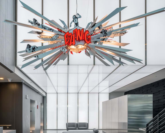 the lobby of a building with a glass ceiling and a neon sign