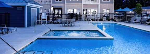 A swimming pool in front of a multi-story apartment building.