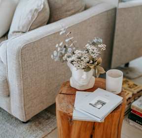 Cozy apartment interior with a wooden table, flowers, and book representing comfortable living at Willow Creek Apartments.