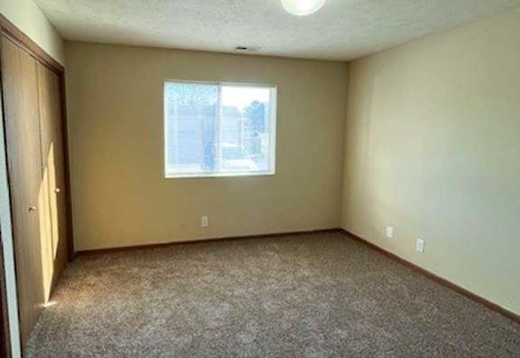 a bedroom with a carpeted floor and a window