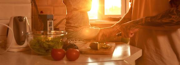 A man and a woman are preparing food in a kitchen.