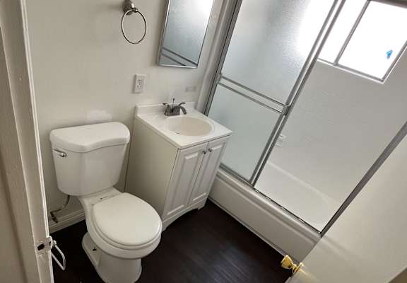 A white toilet and sink in a small bathroom.