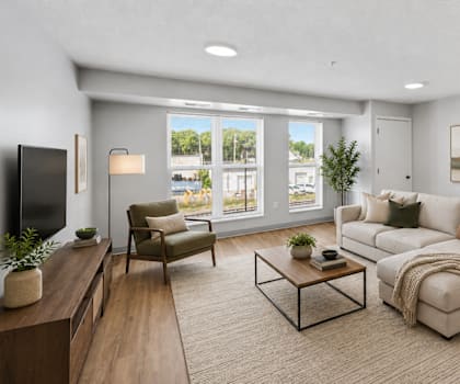 A modern living room with a large window, a sofa, a coffee table, and a TV.