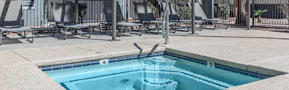 A jacuzzi with lounge chairs nearby