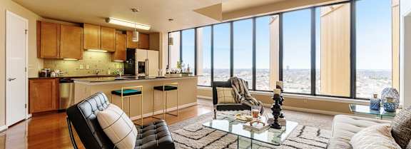 A modern living room with a black leather chair and a glass coffee table.