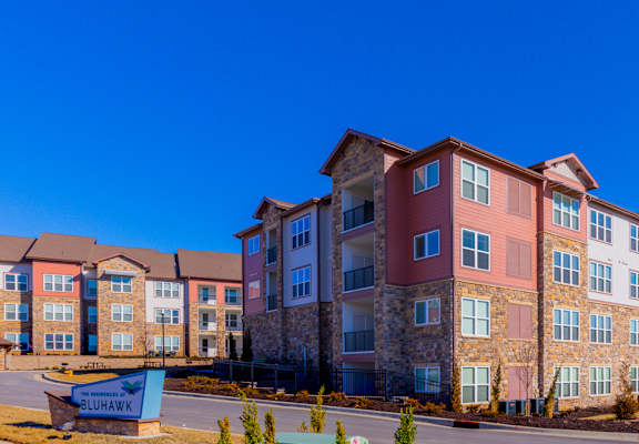 A large apartment complex with a sign that says "Sunrise" in front of it.