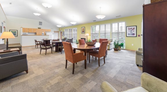 a clubhouse with a dining table and chairs and a kitchen at Horace Mann Apartments and Townhomes in Gary, IN
