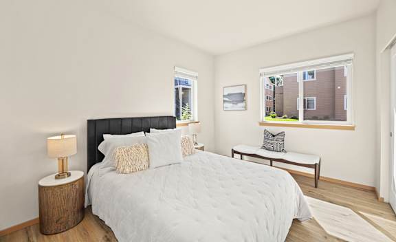 A bedroom with a large bed and a window overlooking a building.