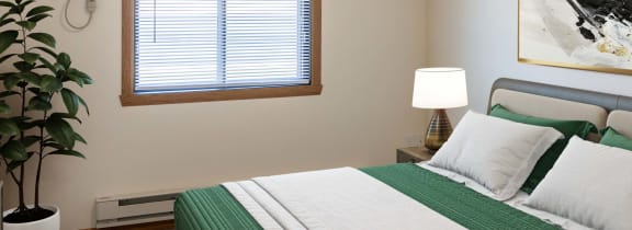 a bedroom with a bed and a painting on the wall