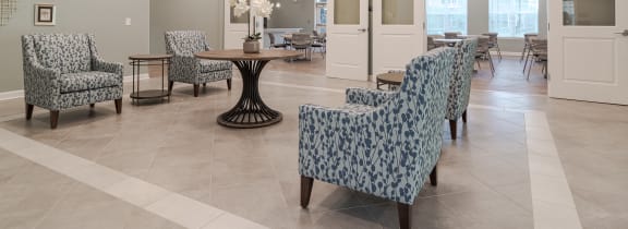 a lobby with chairs and tables in a healthcare facility