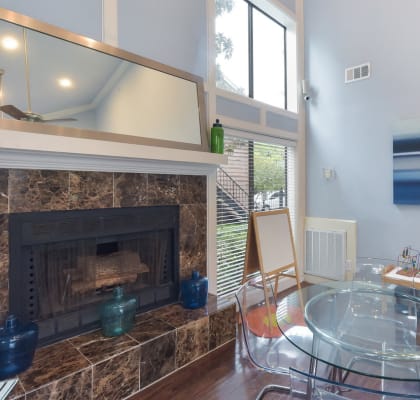a dining room with a glass table and a fireplace at Seacrest Apartments, Texas