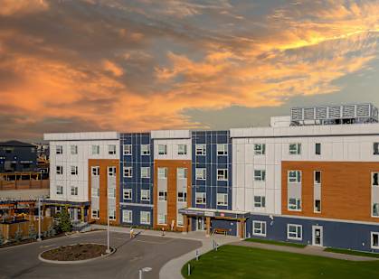 A modern building with a parking lot in front of it.