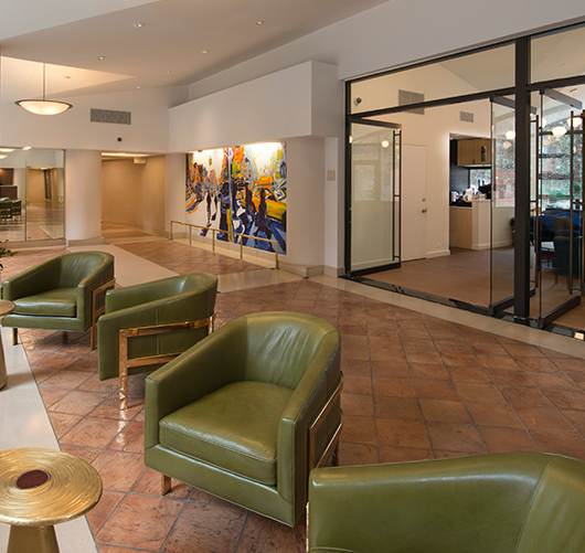 A gym with a variety of equipment including a bench, weights, and a treadmill.at London Terrace Gardens, New York New York
