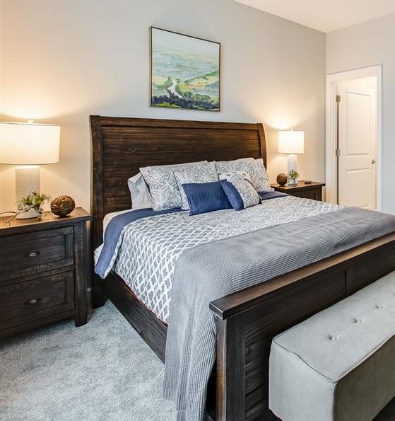 a bedroom with a bed and a dresser and a bathroom at Westport Apartments, VA