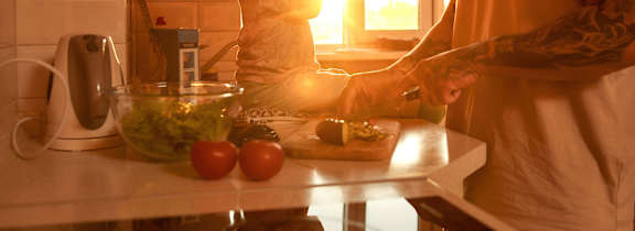 A man and a woman are preparing food in a kitchen.