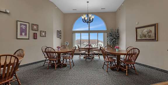 a dining room with a table and chairs and a large window at Savanna Apartments, St Cloud, MN, 56303