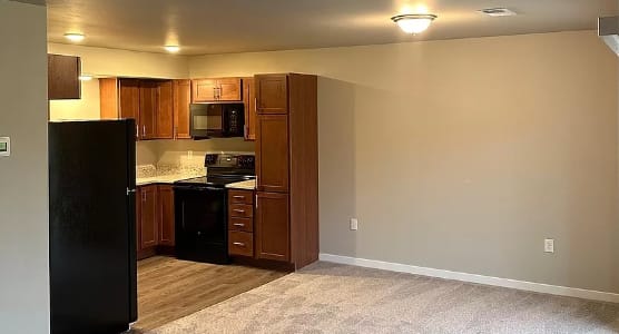 a empty room with a kitchen and a refrigerator