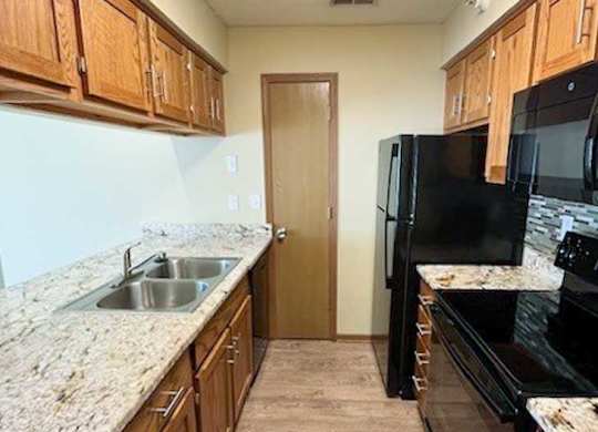 a kitchen with black appliances and wooden cabinets