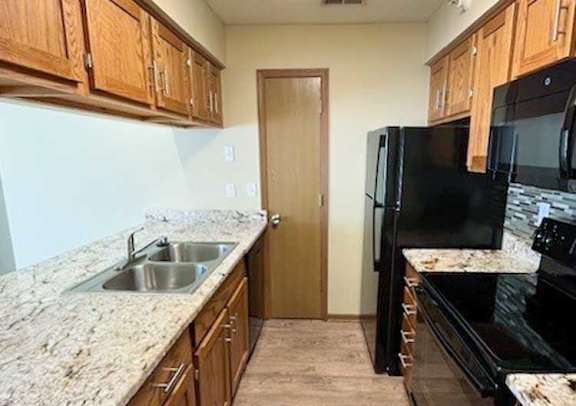 a kitchen with black appliances and wooden cabinets